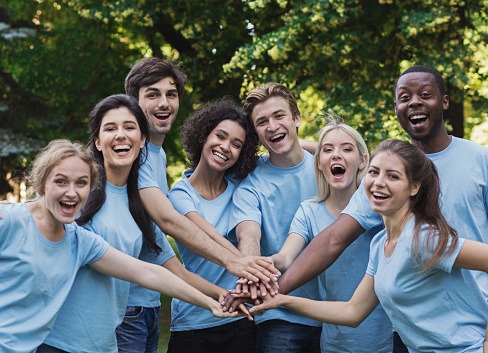 Young happy volunteers outdoor meeting at park